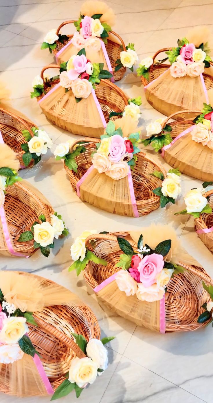 several baskets with flowers on them sitting on the floor next to each other and tied together