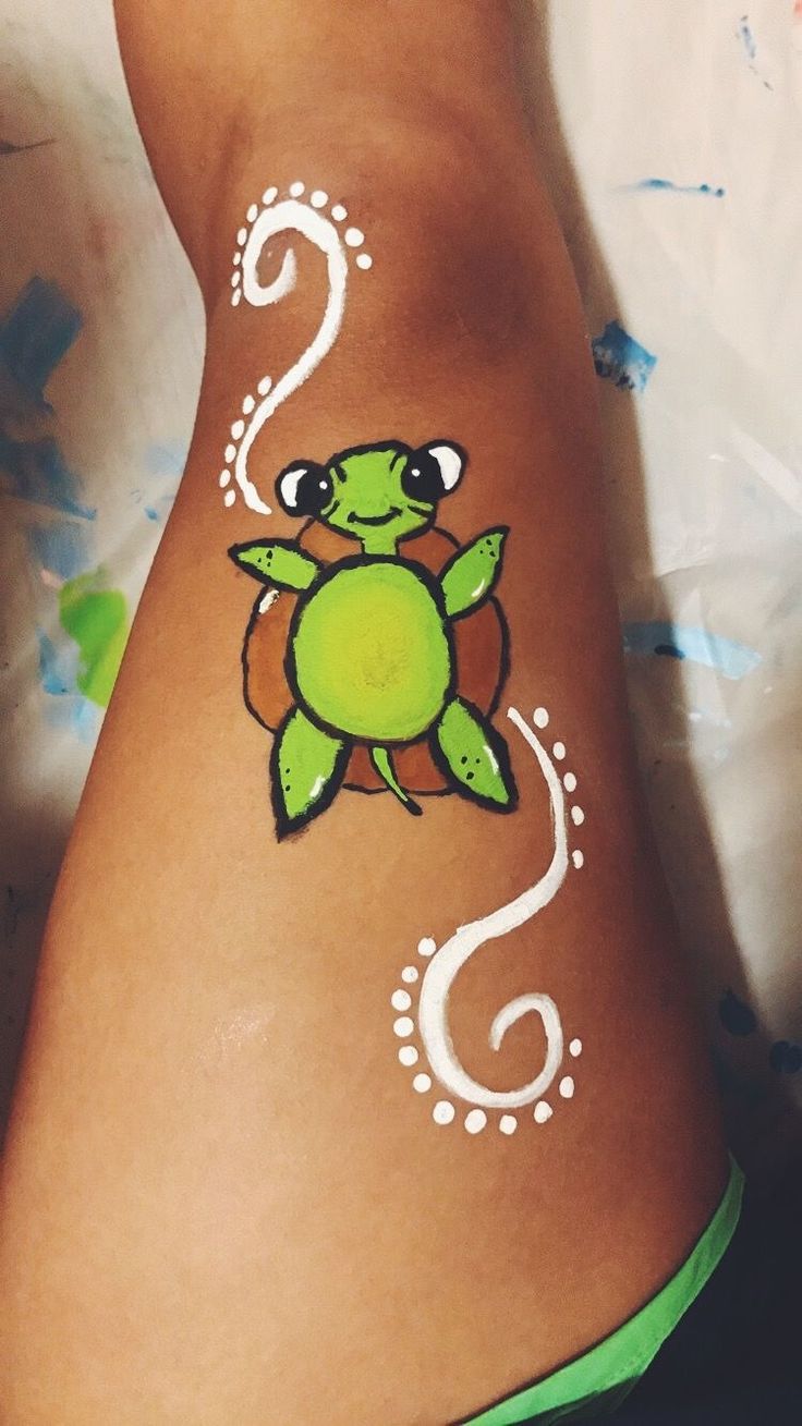 a woman's stomach with an image of a turtle painted on the side of her body