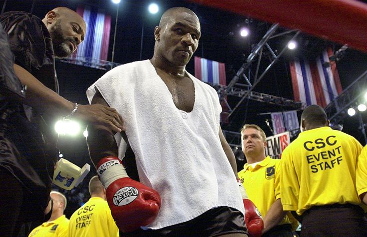 two men standing next to each other with boxing gloves on and one man in white shirt