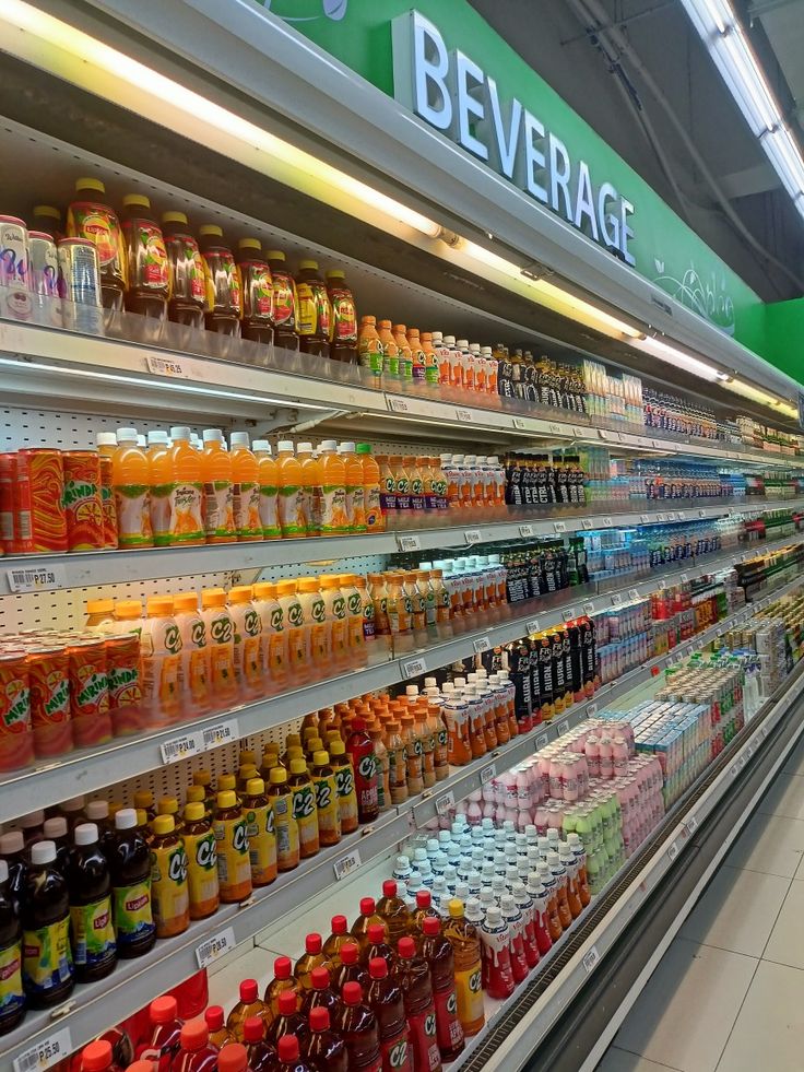 an aisle in a grocery store filled with lots of drinks and juices on display