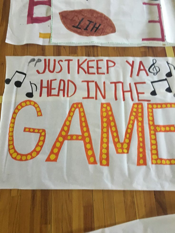 some paper signs that say just keep ya head in the game and have music notes on them