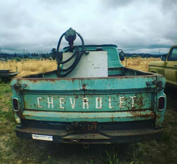 an old chevrolet truck sitting in a field