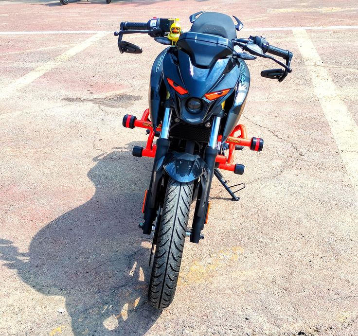 a motorcycle parked in a parking lot with no one around on the bike and it's front tire