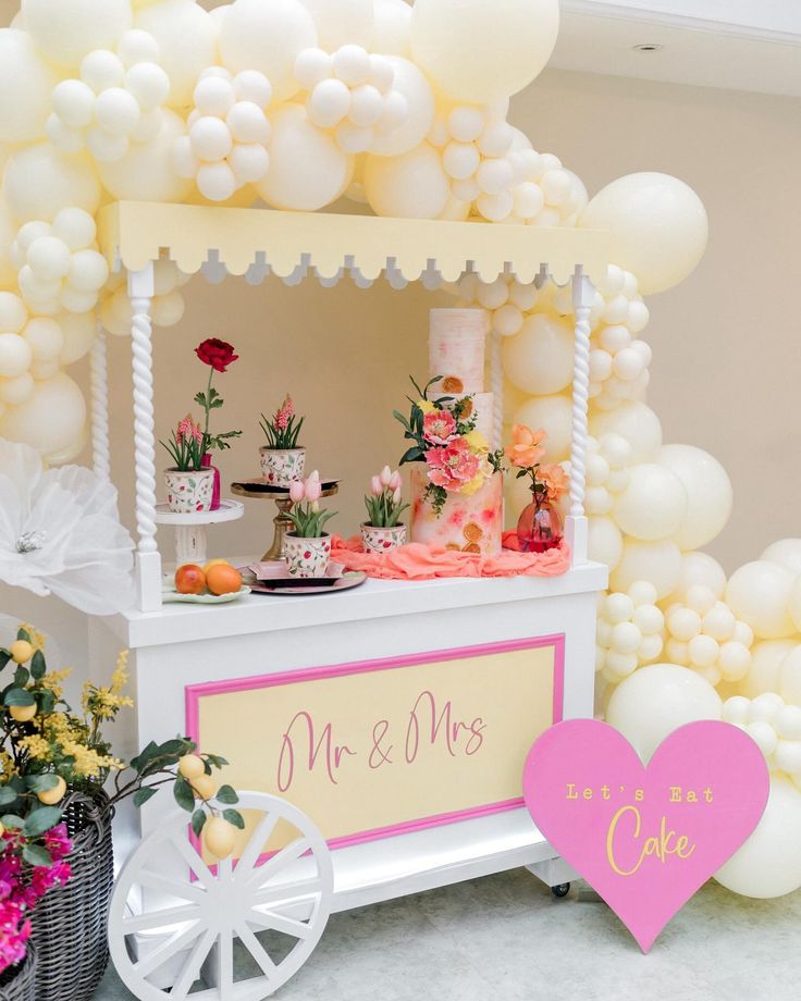 an ice cream cart decorated with balloons, flowers and cake for a wedding or bridal party