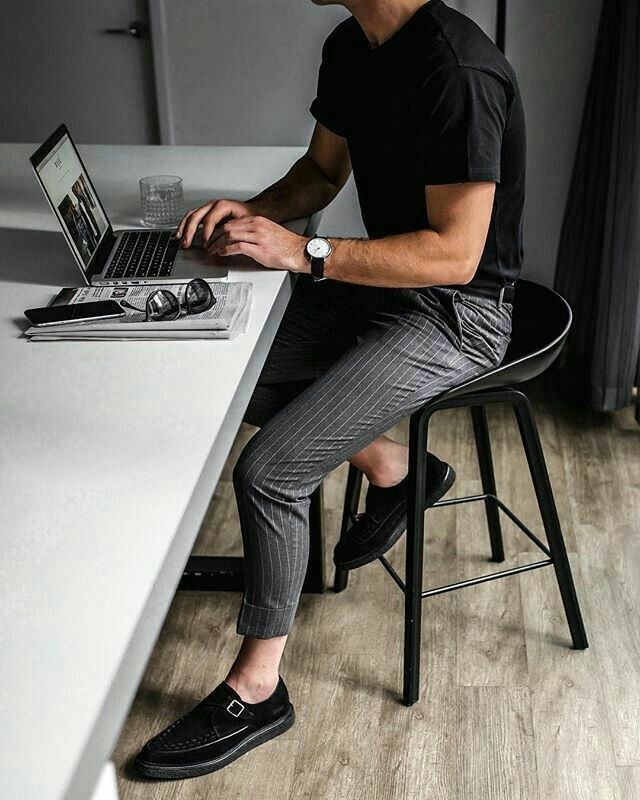 a man sitting at a desk with a laptop computer in front of him and his feet on the table