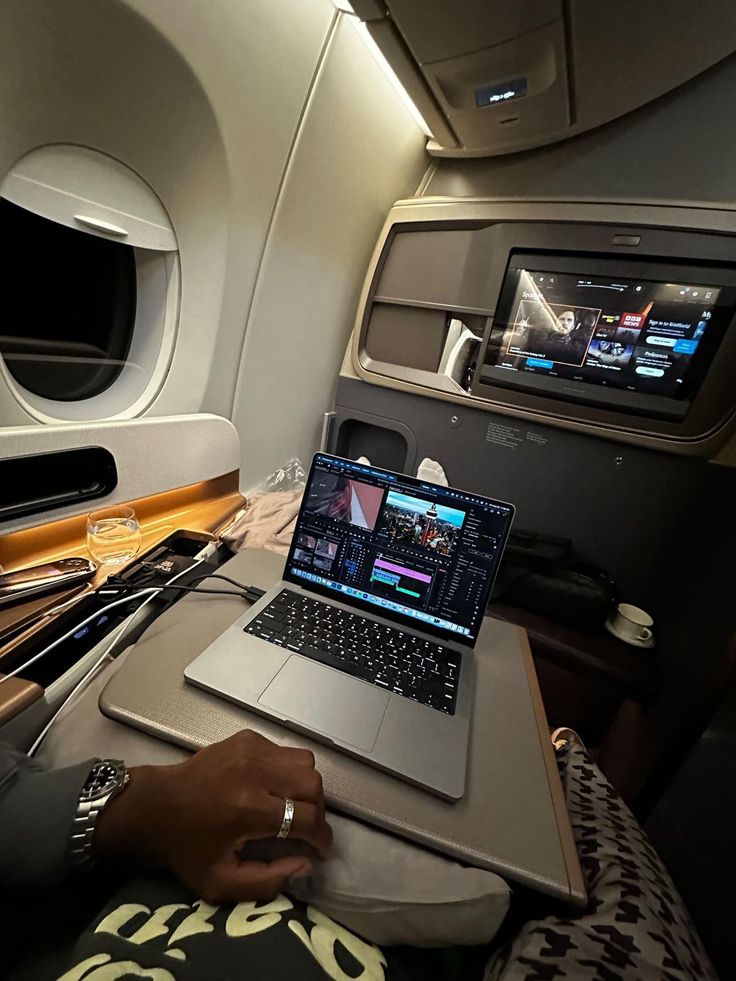 a laptop computer sitting on top of an airplane seat