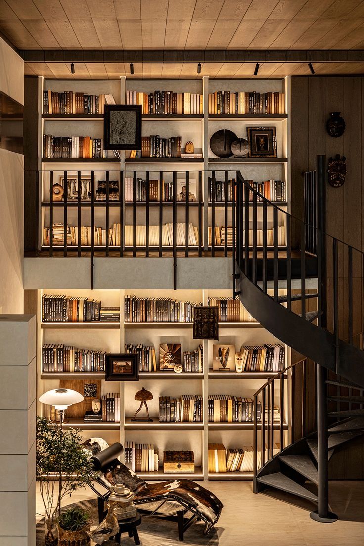 a room filled with lots of books next to a spiral stair case and book shelf