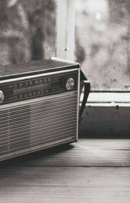 an old radio sitting on top of a wooden table next to a window sill