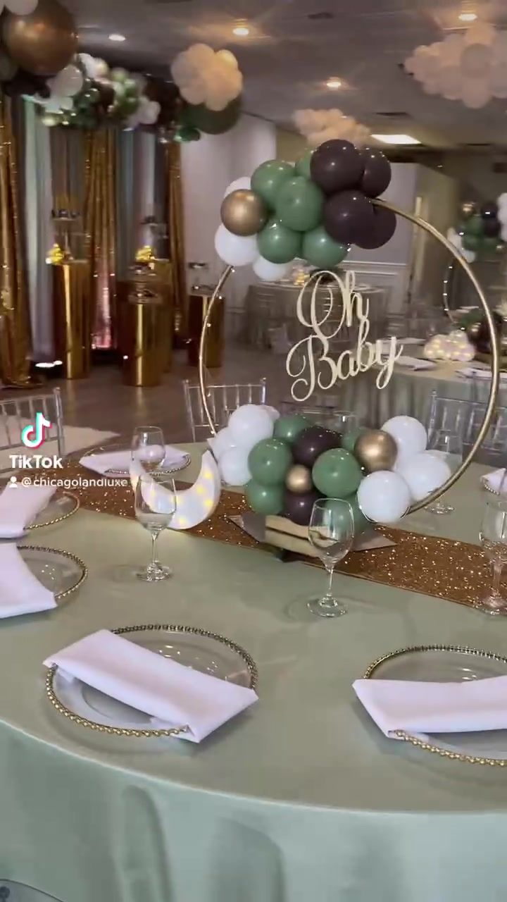 the table is set up for a baby shower with balloons and confetti on it