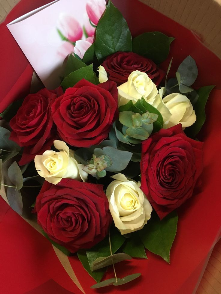 a bouquet of red and white roses in a box