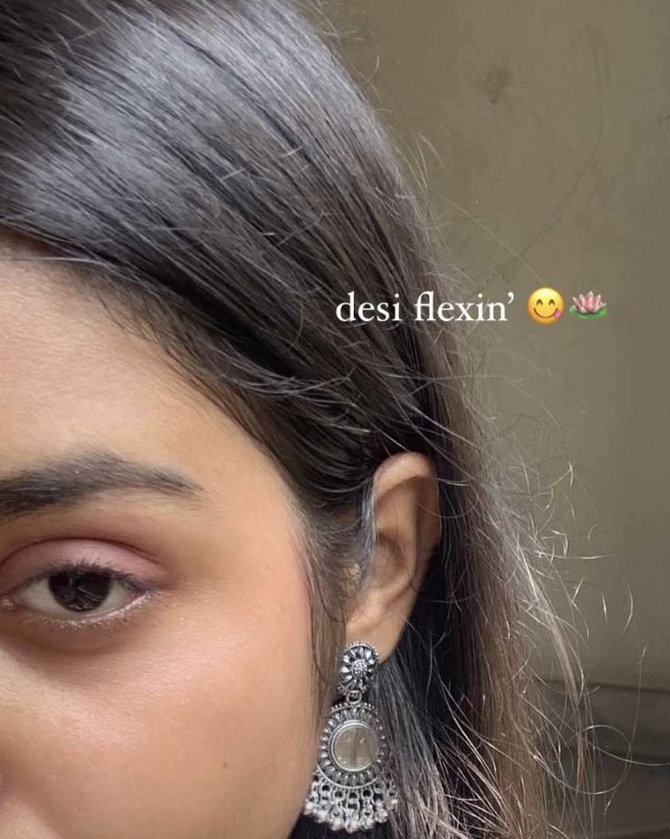 a close up of a person wearing some kind of earring with the words desi flexin on it