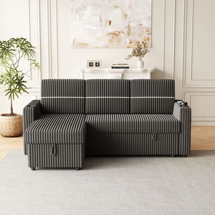 a black and white striped couch sitting on top of a rug next to a potted plant