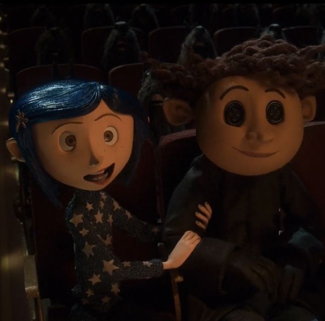 an animated character sitting next to another character in a theater