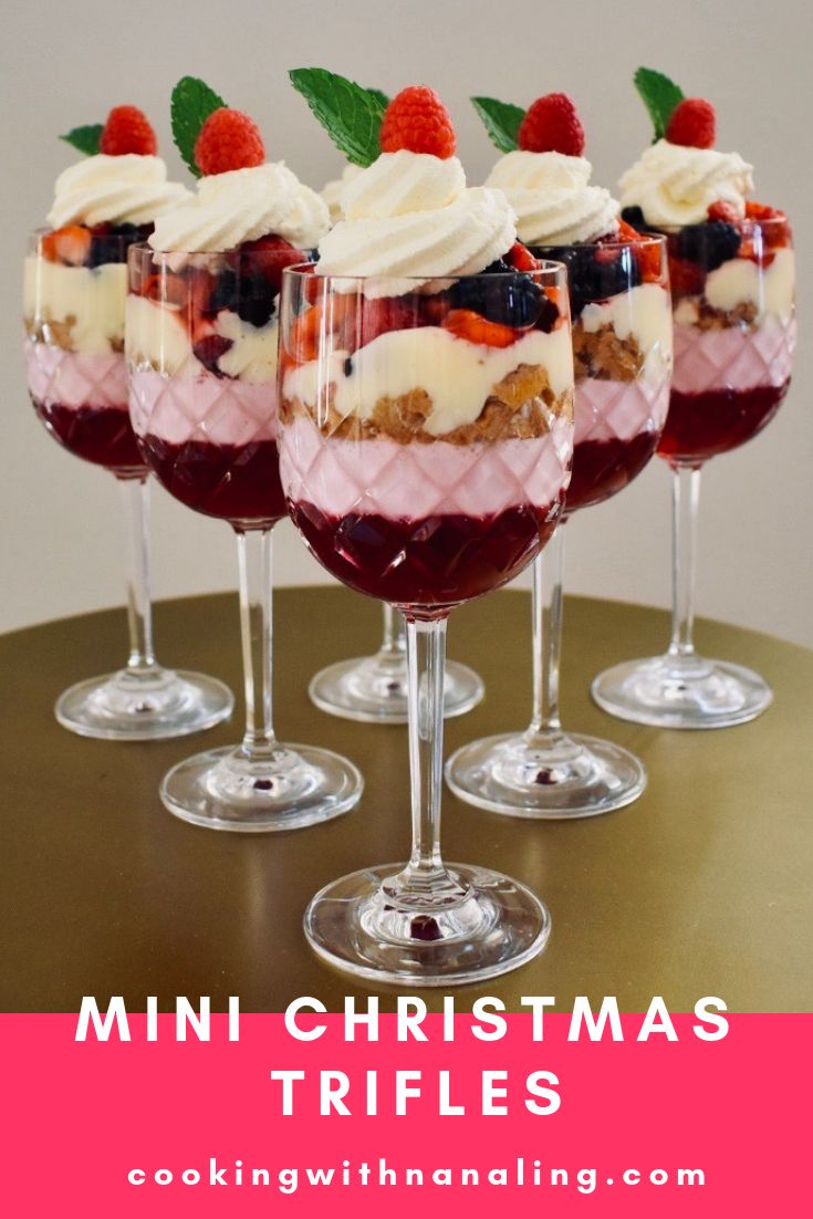 mini christmas trifles with berries and whipped cream in them on a table top