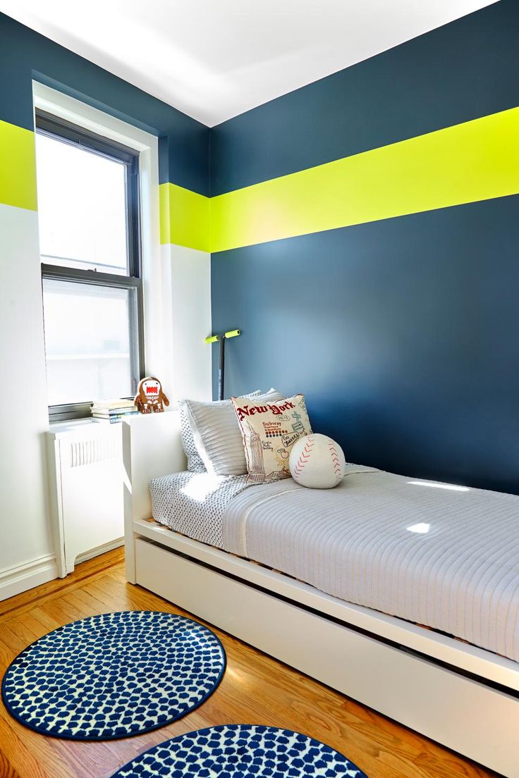 a bedroom with blue, yellow and white stripes painted on the wall next to a bed