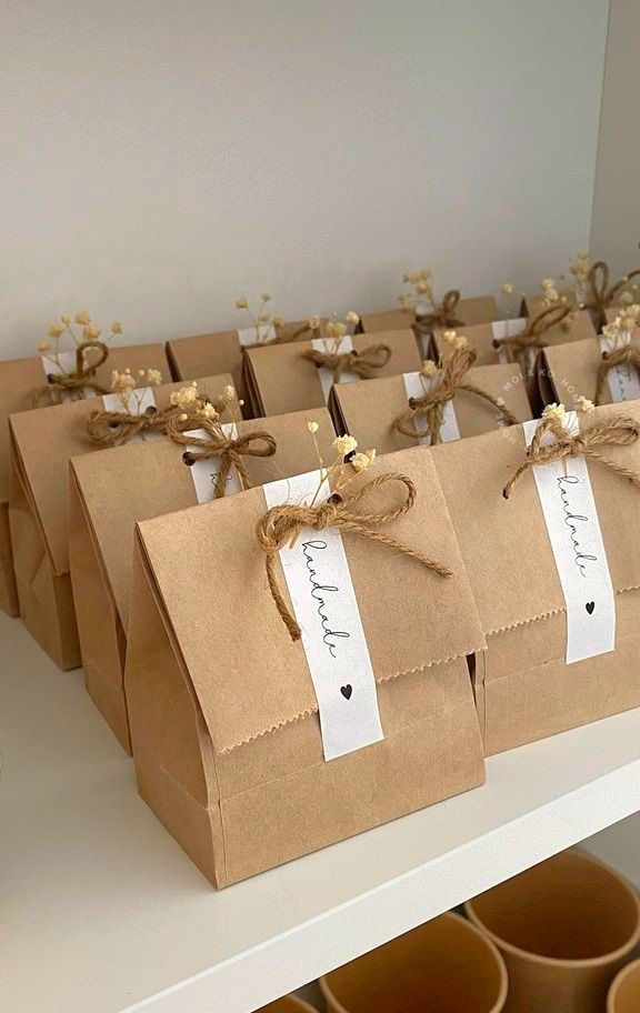 brown paper bags tied with twine and labeled with name tags are sitting on a shelf