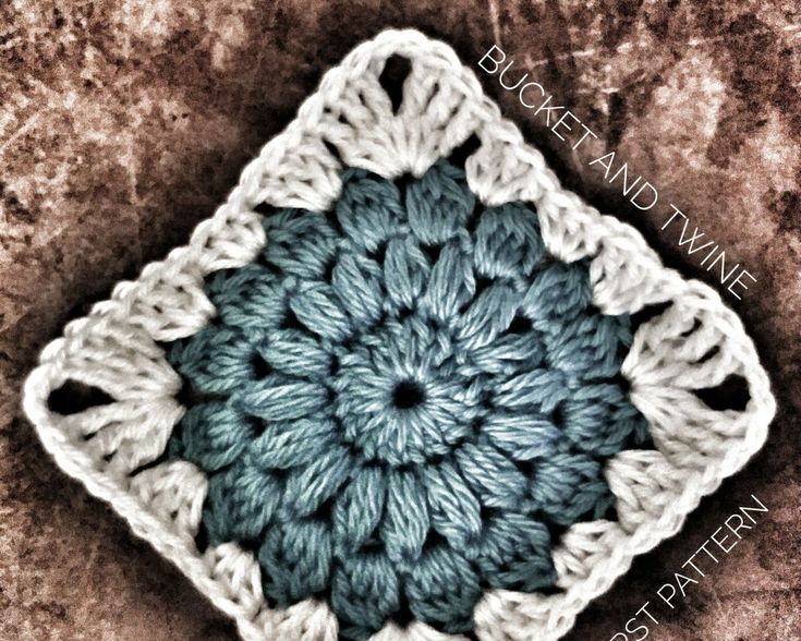 a crocheted square is shown in blue and white