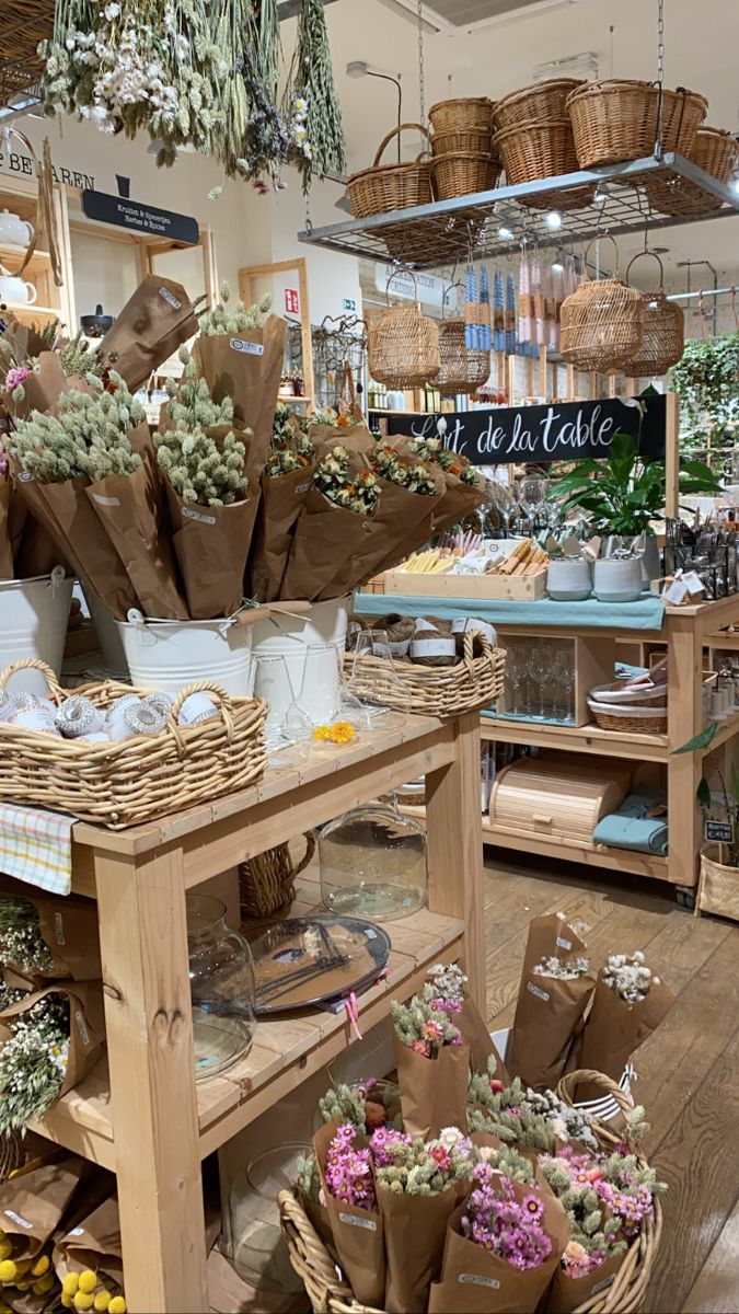 the flower shop is filled with lots of flowers and baskets on display for customers to purchase