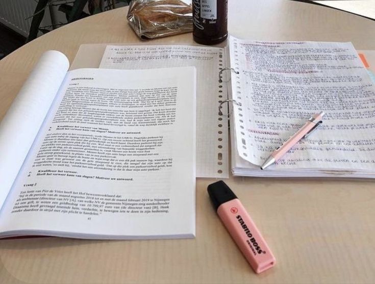 an open book with writing on it next to a pen and bottle of alcohol sitting on a table