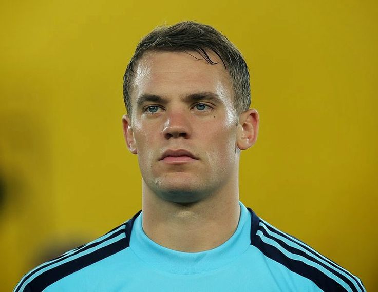 a close up of a soccer player wearing a blue shirt and looking at the camera