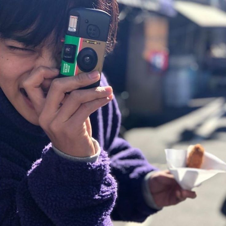 a woman taking a selfie with her cell phone while holding a cup of coffee