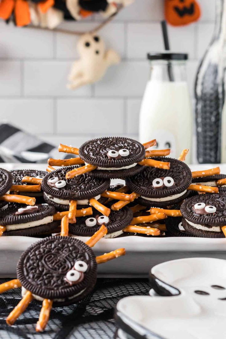 halloween cookies decorated with oreos and googly eyes are on a white platter