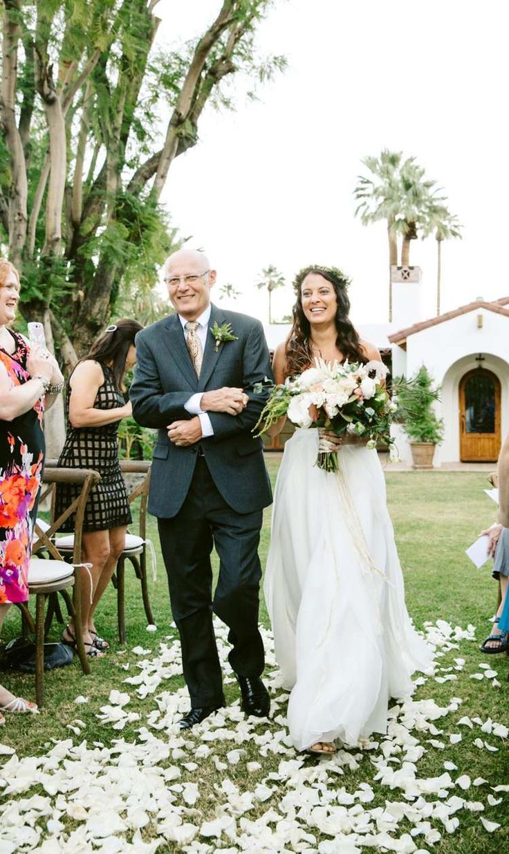 a bride and her father walking down the aisle at their wedding ceremony in palm springs