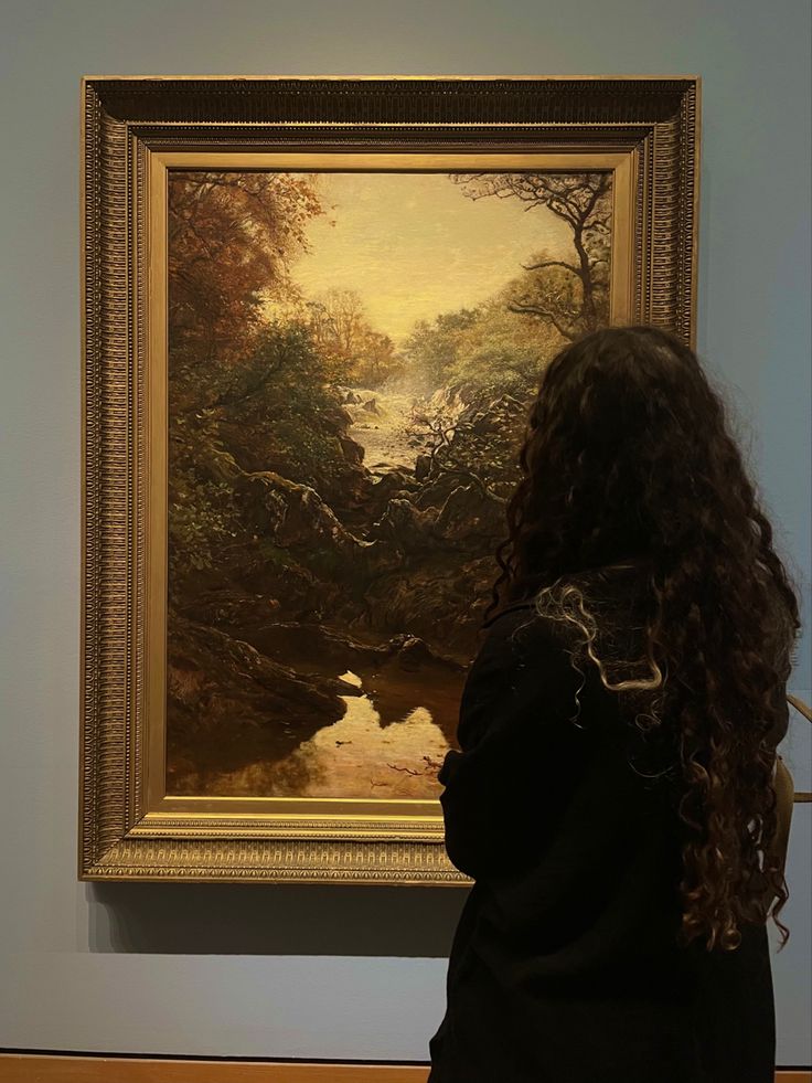 a woman standing in front of a painting looking at it's own water source