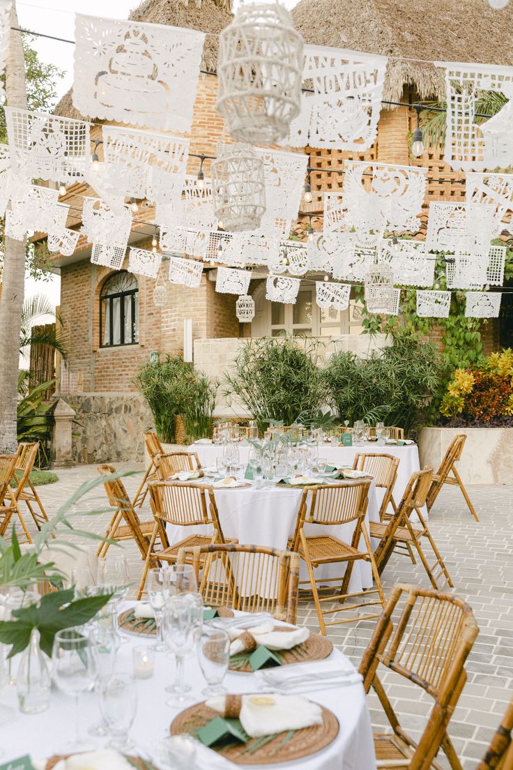 an outdoor dining area with tables and chairs set up for a formal function in front of a building