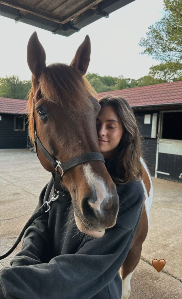 a woman is petting the head of a horse