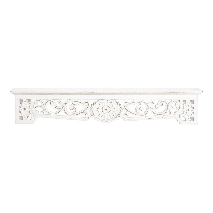 a white shelf with an ornate design on the top and bottom, against a white background