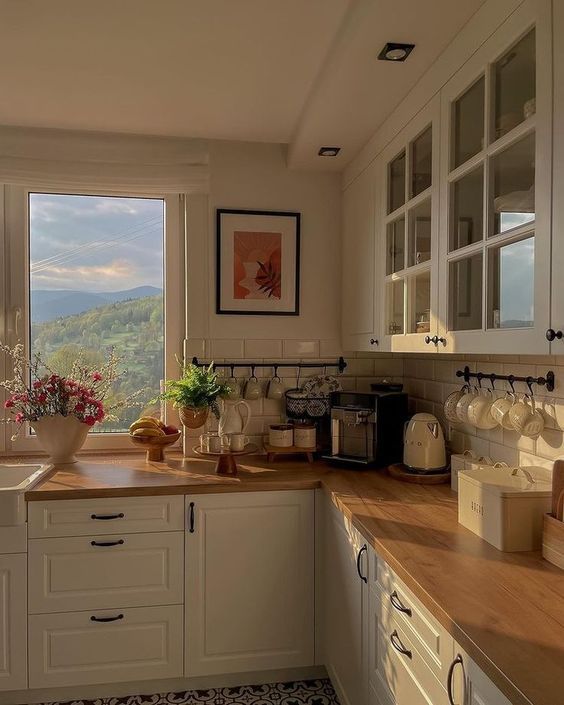 a kitchen filled with lots of counter top space next to a large window overlooking the mountains