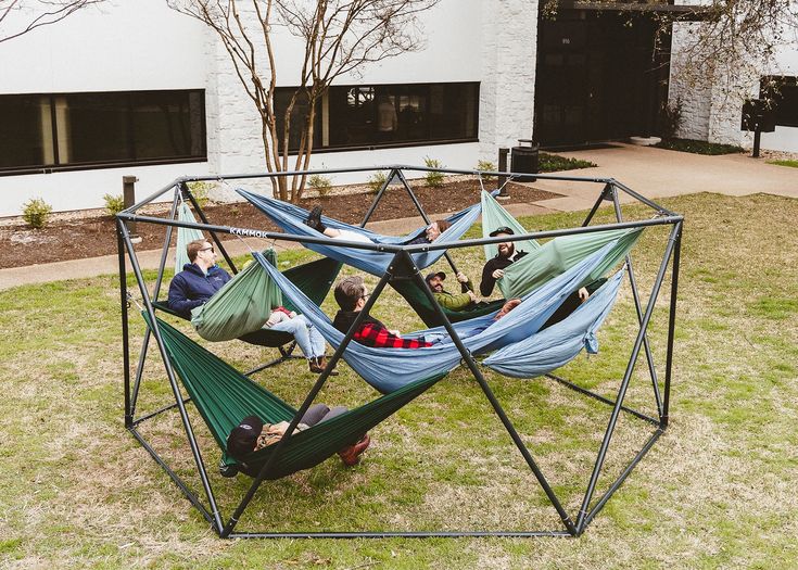 four people sitting in hammocks on the lawn