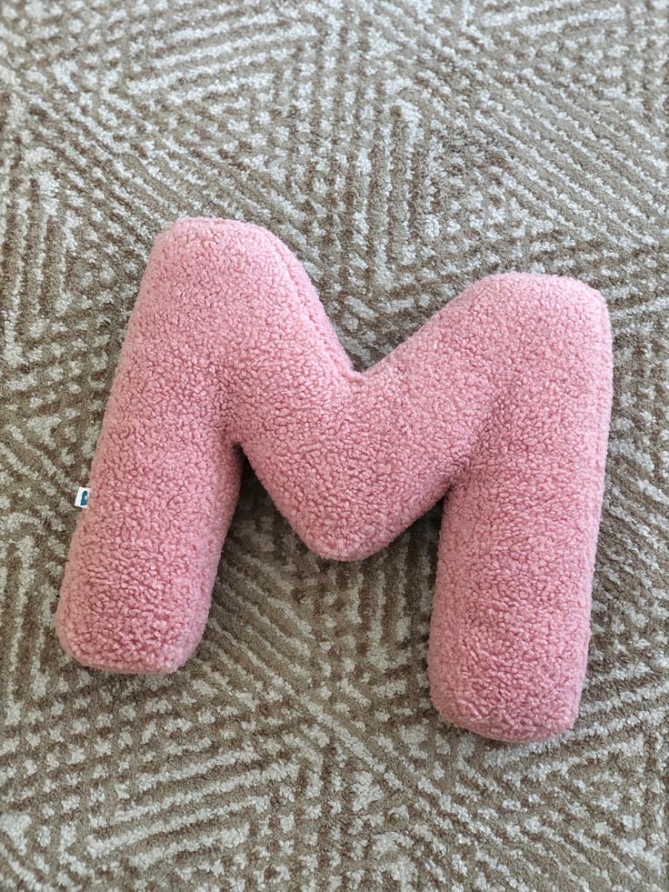 a pink stuffed animal laying on top of a carpet