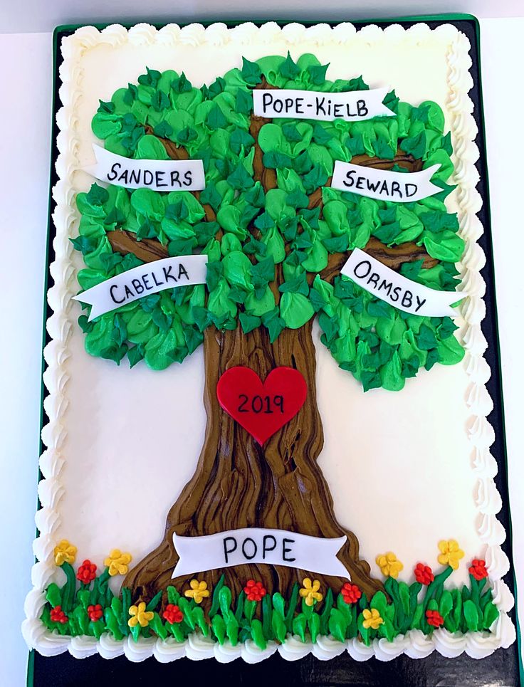 a cake decorated to look like a tree with names on it and hearts in the leaves