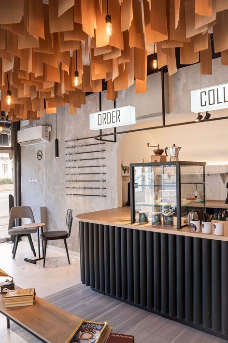 the interior of a coffee shop with wooden lights hanging from the ceiling