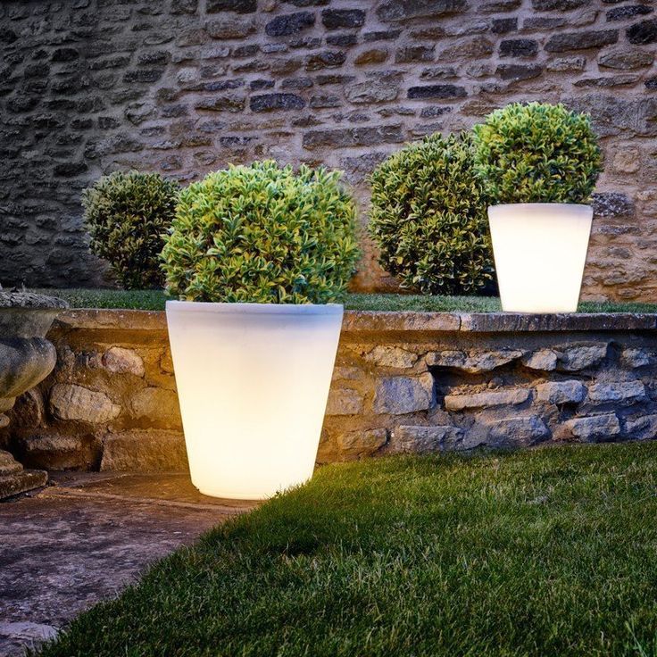 two large white planters sitting next to each other on top of a grass covered field