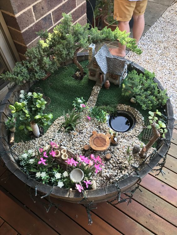 a miniature garden in a pot on a wooden deck