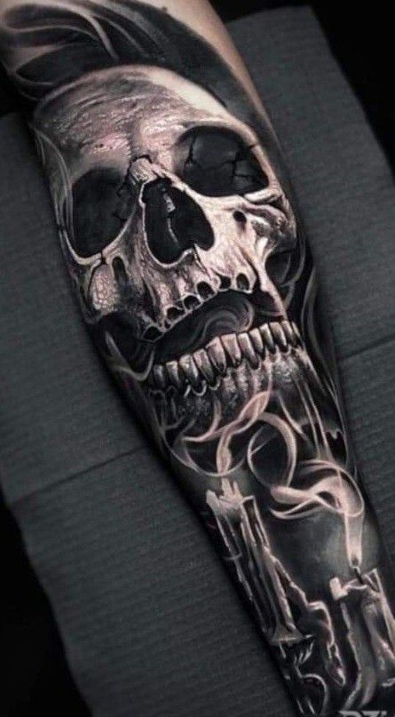 a man's arm with a black and white skull tattoo on it