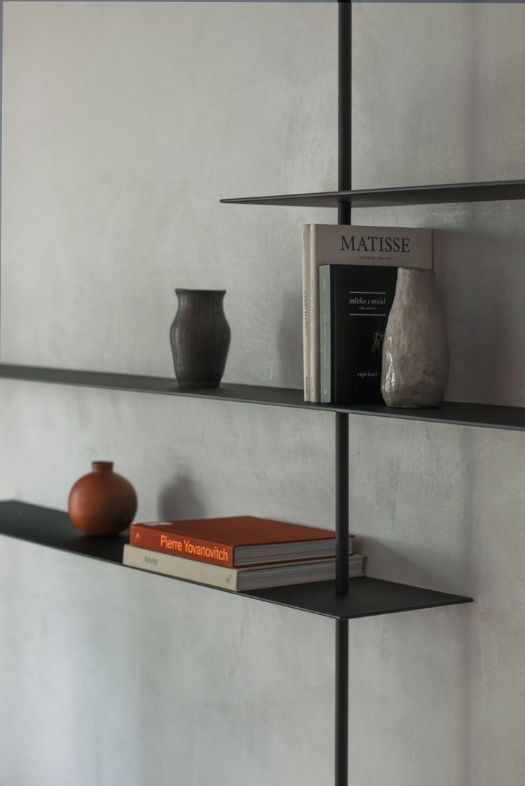 three shelves with books and vases on them