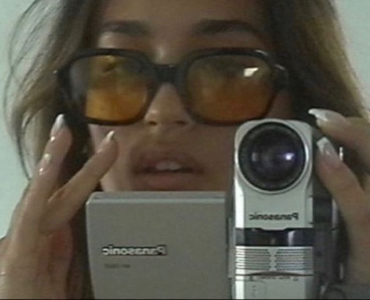 a woman holding up a camera to her face