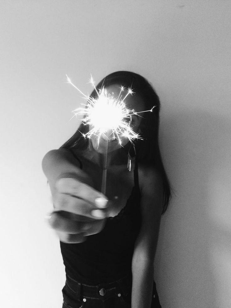 a woman is holding a sparkler in her hand and pointing it at the camera