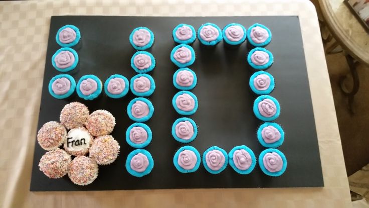 cupcakes are arranged in the shape of the word love on a table with a flower