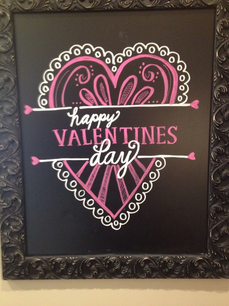 a valentine's day chalkboard is hanging on the wall in front of a black frame