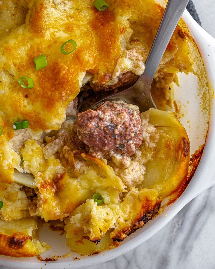 a white bowl filled with meat and vegetable casserole