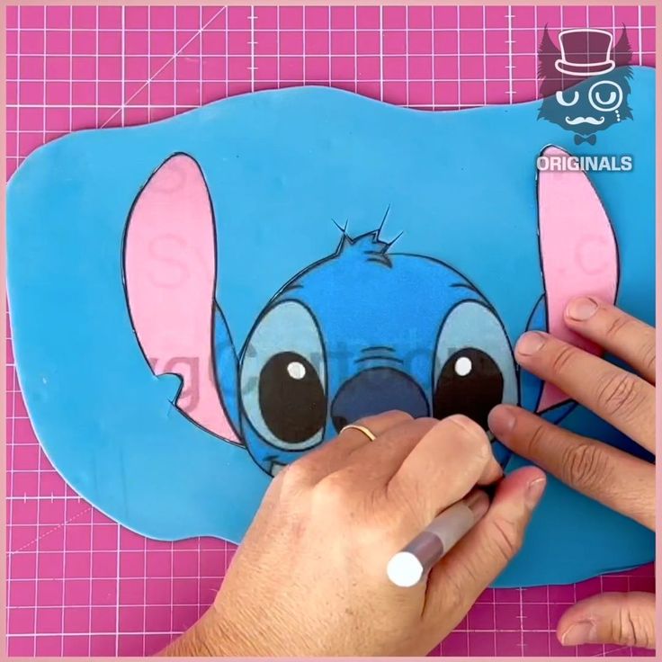 someone is cutting out the face of a cartoon character from an image on a piece of paper