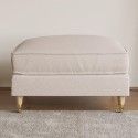 a white footstool sitting on top of a rug in front of a window