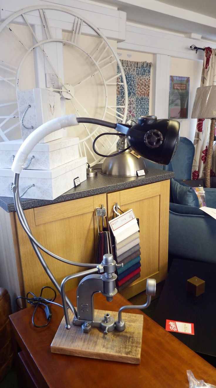 a desk lamp sitting on top of a wooden table next to a blue couch in a living room