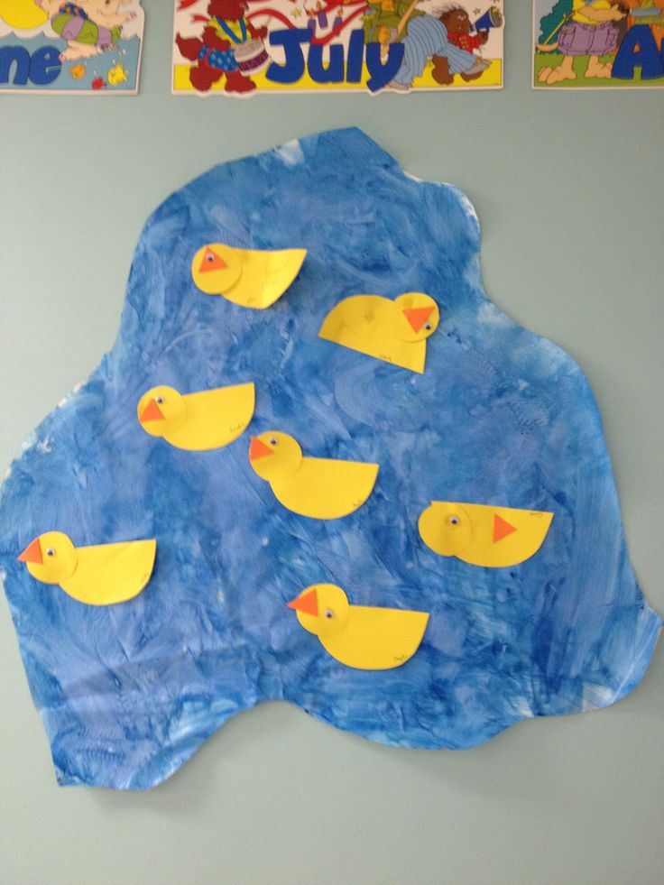 paper mache with yellow rubber ducks on blue background and children's books above