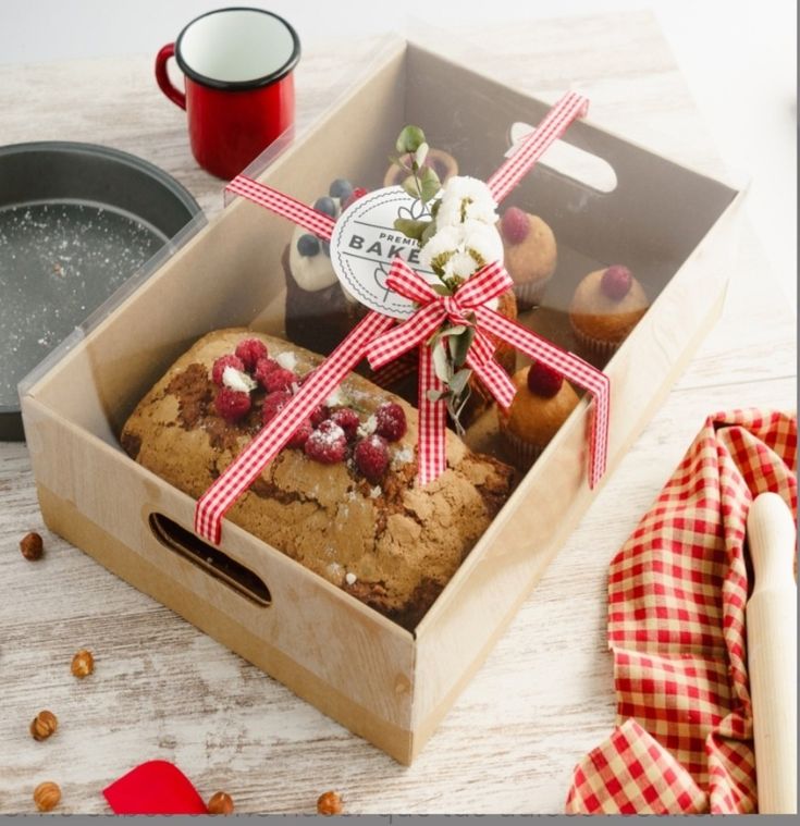 a box with some food inside of it on a table next to a red and white checkered napkin